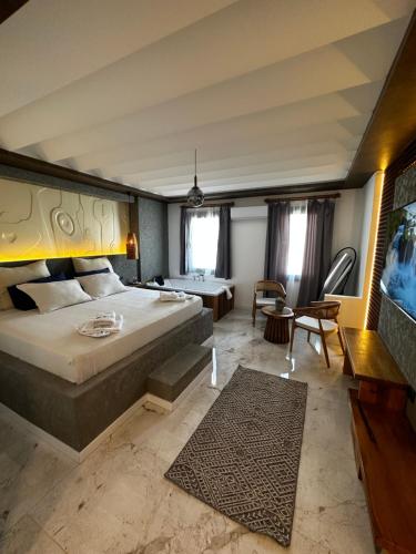 a bedroom with a large bed and a living room at RÜYA BOHEME HOTEL BODRUM in Bodrum City