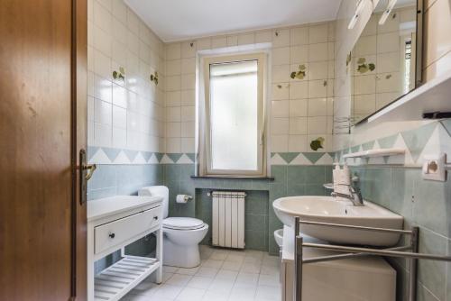 a bathroom with a sink and a toilet and a mirror at Ortensia Apartments by Wonderful Italy in Aci Castello