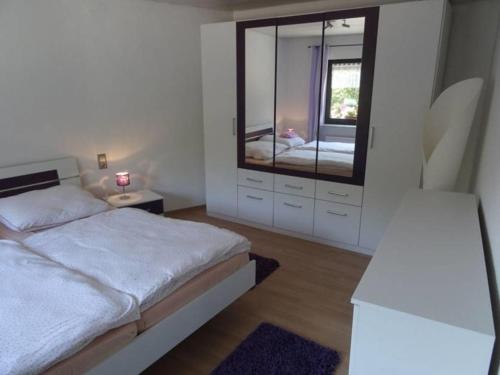 a bedroom with a bed and a large mirror at Ferienwohnung "Udri" in Oberwürzbach