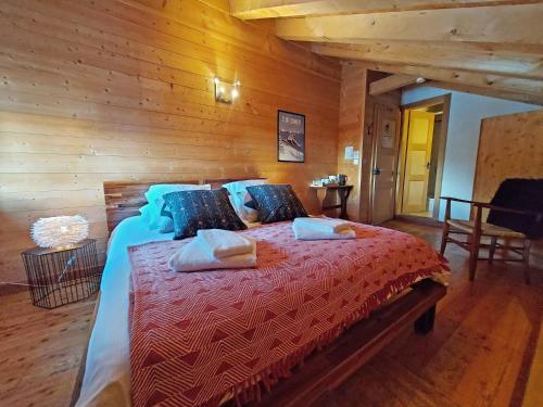 ein Schlafzimmer mit einem großen Bett und einer Holzwand in der Unterkunft Gîte du Prilet in Saint-Luc
