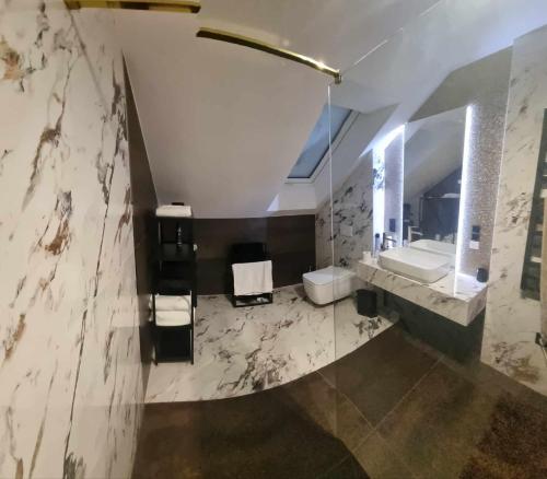 een badkamer met een wastafel, een toilet en een spiegel bij Pustelnika Chatka nad Brennicą in Brenna