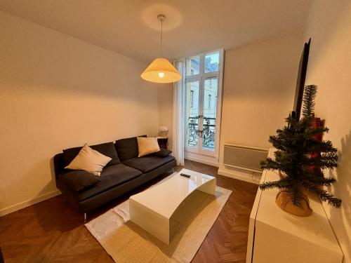 a living room with a couch and a christmas tree at Appartement au centre-ville à 100 m des télécabines avec parking souterrain gratuit in Luchon