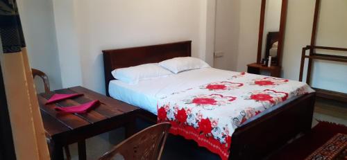 a bedroom with a bed with a red and white blanket at Daresh hime stay in Maskeliya