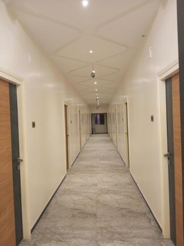 um corredor de um edifício de escritórios com paredes brancas em VJ GRAND LODGE N FUNCTION HALL 