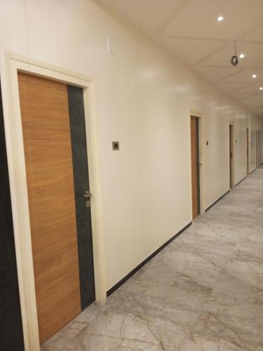 um corredor vazio com uma porta e uma fila de quartos em VJ GRAND LODGE N FUNCTION HALL 