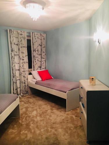 ジェロナ・グラにあるAPARTAMENT STRUMYKOWAのベッドルーム1室(赤い枕付きのベッド1台付)