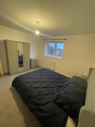 a bedroom with a large black bed in a room at 3 swallow close IDEAL FOR CONTRACTORS , FAMILIES AND WEEKEND STAYS in Olney