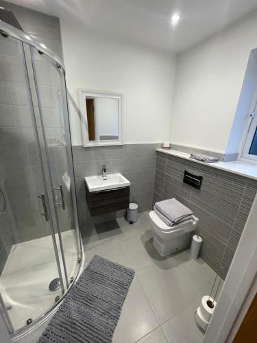 a bathroom with a shower and a toilet and a sink at 3 swallow close IDEAL FOR CONTRACTORS , FAMILIES AND WEEKEND STAYS in Olney