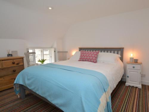 a bedroom with a large bed with a blue blanket at 2 Bed in Burton Bradstock DC166 in Burton Bradstock