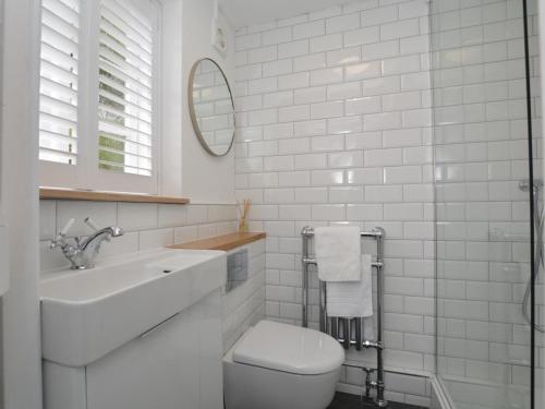 a bathroom with a toilet and a sink and a mirror at 2 Bed in Burton Bradstock DC166 in Burton Bradstock
