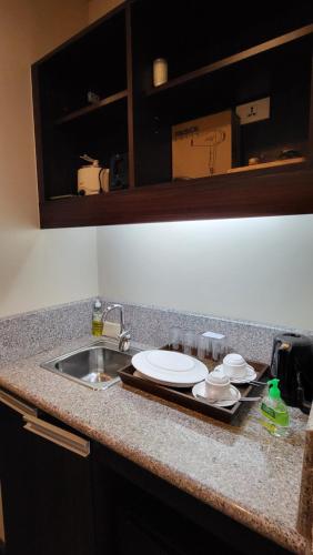 a kitchen counter with a sink and a plate on it at Unit 551,Privately Owned, Superior Room At the Forest Lodge Camp John Hay, Mountain View, 2 Double Beds in Baguio