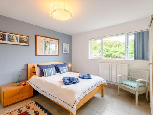 a bedroom with a bed and a chair and windows at 3 Bed in Worth Matravers DC140 in Worth Matravers