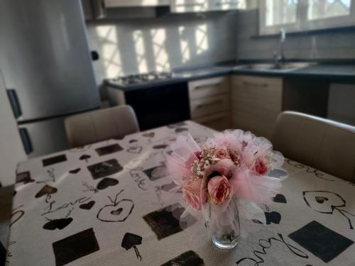 un jarrón con flores rosas sobre una mesa en una cocina en DiVino relax among the vineyards, en Frascati