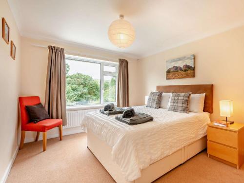 a bedroom with a bed and a red chair at 4 Bed in Studland 75639 in Studland