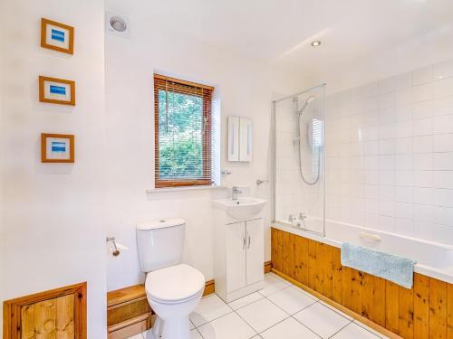 a bathroom with a toilet and a tub and a sink at 3 Bed in Stoborough DC157 in Stoborough