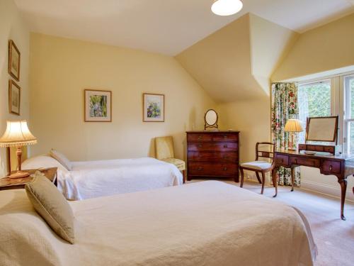 a bedroom with two beds and a desk and a piano at 6 Bed in Kinlocheil CA139 in Fassfern