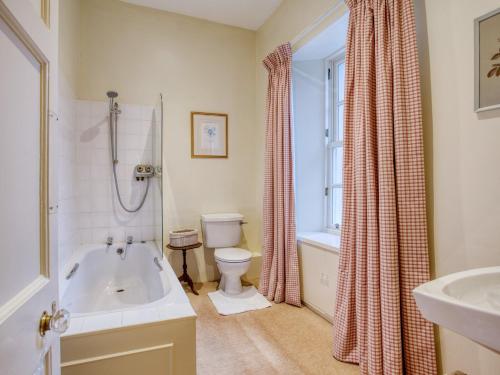 a bathroom with a tub and a toilet and a sink at 6 Bed in Kinlocheil CA139 in Fassfern