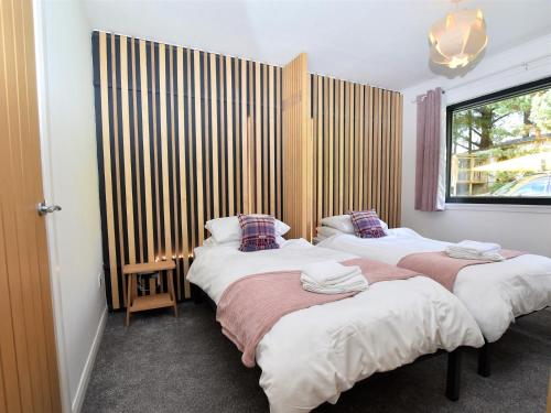 two beds in a room with a window at 3 Bed in Pitlochry CA207 in Struan