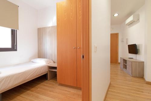 a small room with a bed and a closet at Hotel Sagunto in Sagunto