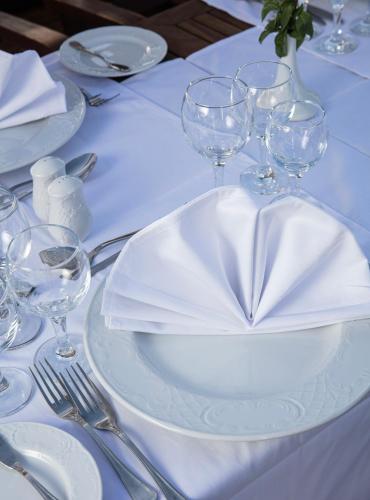 a white plate with a napkin on a table with wine glasses at Farouz El Nil II Nile Cruise - Every Monday from Luxor for 07 & 05 Nights in Luxor