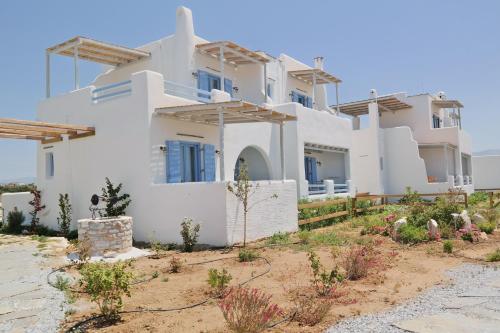 a large white house with blue windows at Annio studios in Plaka