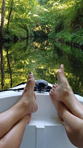 a person with their feet on a boat on a river at Le Manivert in Vitry-Laché
