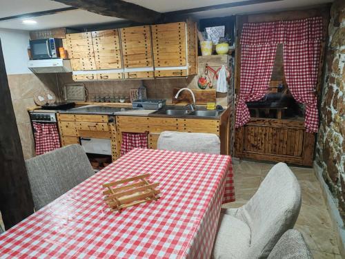 a kitchen with a red and white checkered table and chairs at Vila Antić in Pirot