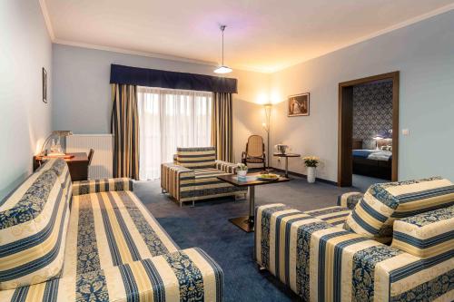 ein Hotelzimmer mit 2 Betten und einem Wohnzimmer in der Unterkunft Hotel Studanka in Rychnov nad Kněžnou