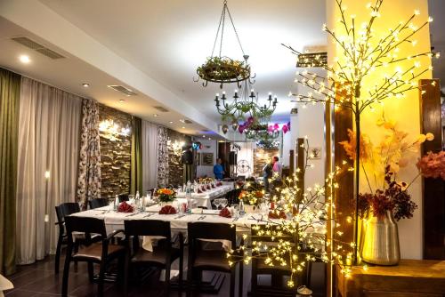 ein Esszimmer mit einem langen Tisch mit Stühlen und Lampen in der Unterkunft Park Hotel Fairy in Chiflik