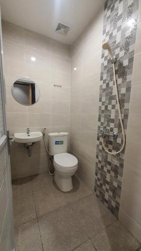 a bathroom with a toilet and a sink at Check Inn Permata Hijau in Semarang
