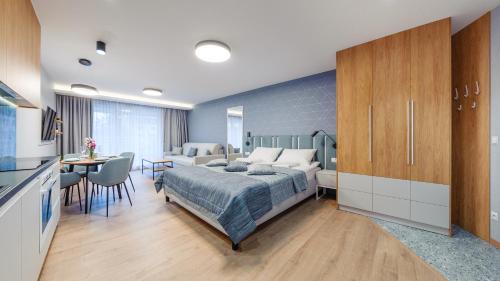 a bedroom with a bed and a kitchen with a table at Apartamenty Sun & Snow Na Klifie in Władysławowo