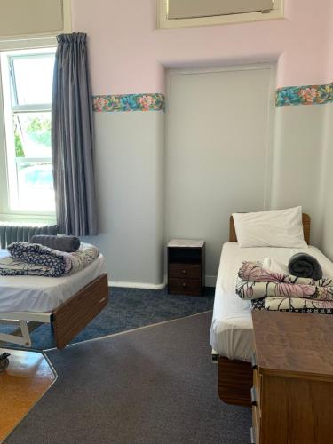 a bedroom with two beds and a window at Thomas's Catlins Lodge and Camp Ground in Owaka