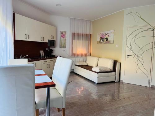 a kitchen and living room with a couch and a table at Villa Relax Apartman in Gárdony