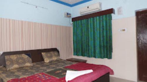 a bedroom with a bed with a green curtain at HOTEL TAJ DELUXE, Agra in Agra