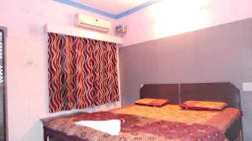 アグラにあるHOTEL TAJ DELUXE, Agraのベッドルーム1室(ベッド1台、赤いカーテン付)