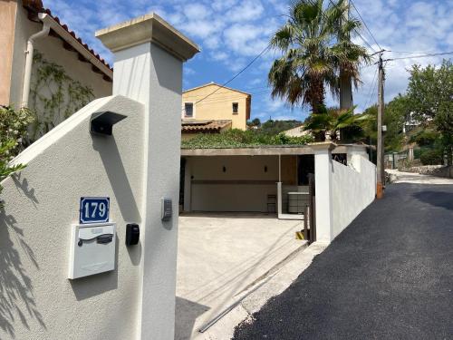 a building with a gate with a sign on it at Sublime logement avec vue mer et Jacuzzi in La Ciotat