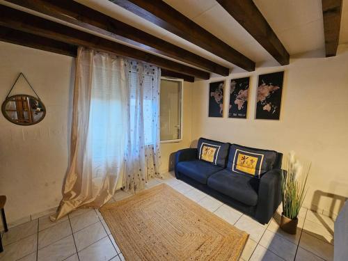 - un salon avec un canapé et une fenêtre dans l'établissement Triplex Proche Charles De Gaulle, à Vaujours