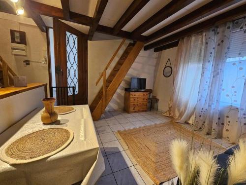 a kitchen with a table and a staircase with a window at Triplex Proche Charles De Gaulle in Vaujours