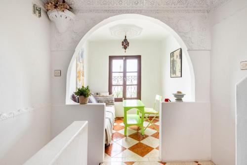a living room with an archway and a green chair at Maison Ghazal in Tangier