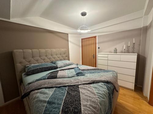 a bedroom with a bed and a dresser at cream apartment in Banja Luka