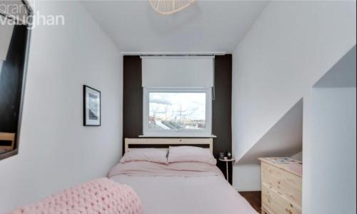 a small bedroom with a bed and a window at Central Hove Quiet Top Floor Flat with Terrace in Brighton & Hove