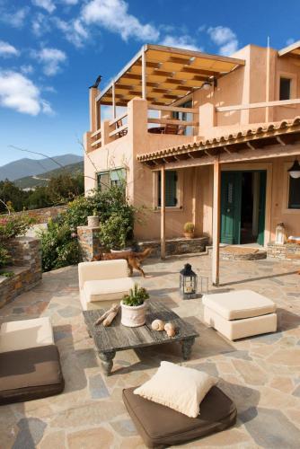 a patio with couches and a table in front of a house at Wavefront Serenity - Exotic & Dreamy Getaway in Marmarion