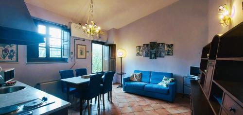 a living room with a table and a blue couch at Le Civette Country Resort in Bagno a Ripoli
