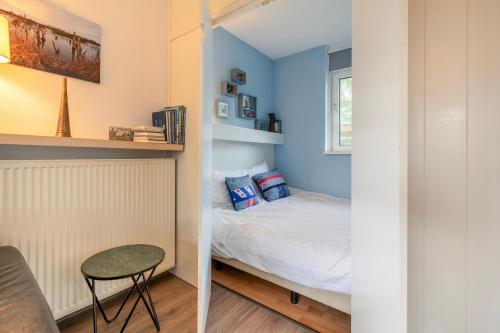 a small bedroom with a bed and a small table at Summio Vakantiepark It Wiid in Earnewâld