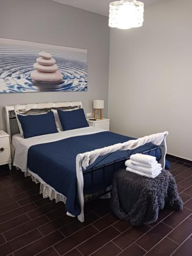 イオス島 チョーラにあるMentas Country Villaのベッドルーム1室(青いシーツと絵画付)