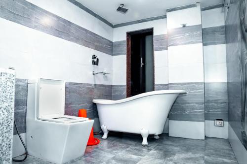 La salle de bains est pourvue d'une baignoire blanche et d'un lavabo. dans l'établissement Hotel Kamana, à Pokhara