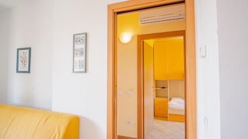 Habitación con una puerta que conduce a un dormitorio en Garda Orange Apartment - Italian Homing, en Desenzano del Garda