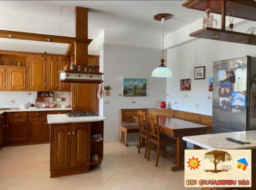 a kitchen with wooden cabinets and a table in it at A CASA DI STÈ - Vicino aeroporto Falcone Borsellino in Carini
