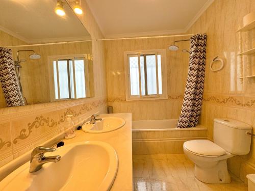 a bathroom with a sink and a toilet and a mirror at Villa Jazmin in Nerja