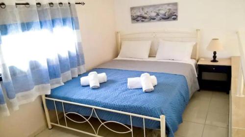 a bedroom with a bed with two towels on it at LEFKES Apartments Sidari in Sidari